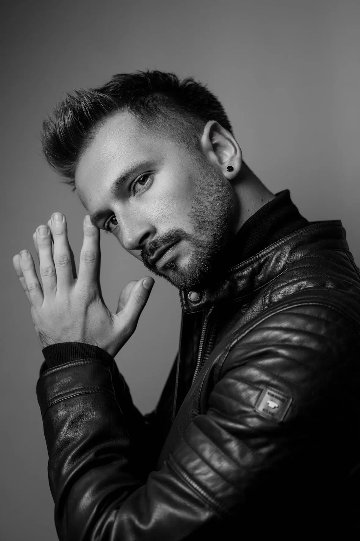 Choreograf Chris Trybuś patrzy w stronę aparatu który go fotografuje.
